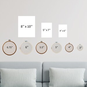 a living room with a couch and a set of cross stitch wall hangings