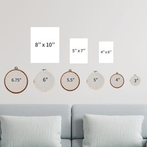 a living room with a couch and a set of cross stitch wall hangings