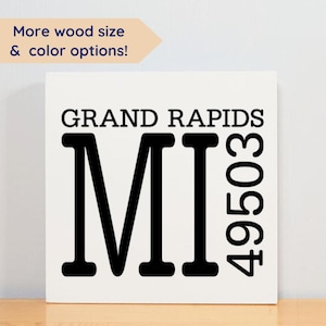 May include: White wooden sign with black text that reads "GRAND RAPIDS MI 49503".