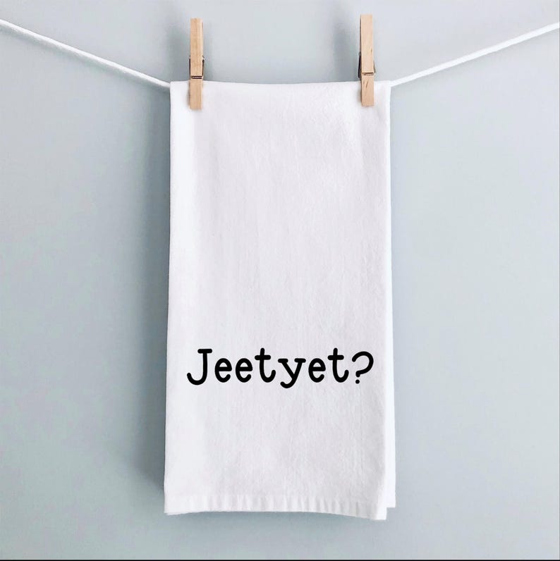 May include: White kitchen towel with the text "Jeetyet?" printed in black.