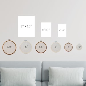 a living room with a couch and a set of cross stitch wall hangings