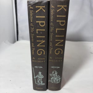 Puede incluir: Dos libros antiguos titulados "KIPLING A Selection of His Stories and Poems" de John Beecroft. Los libros son de color marrón oscuro con letras e ilustraciones doradas. El editor es Doubleday.