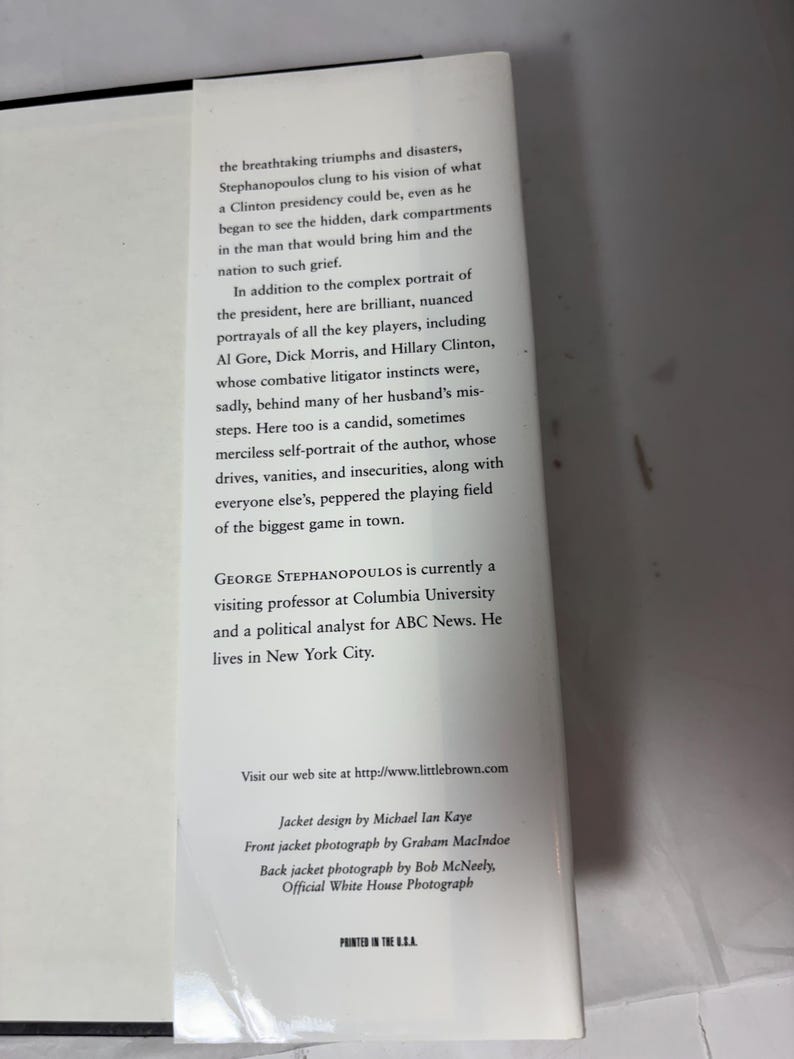 Puede incluir: Contraportada de un libro con texto blanco sobre fondo blanco. El texto describe el contenido del libro, incluyendo menciones de George Stephanopoulos, Hillary Clinton y Al Gore. La cubierta tambi&eacute;n incluye la informaci&oacute;n del autor y la direcci&oacute;n del sitio web.