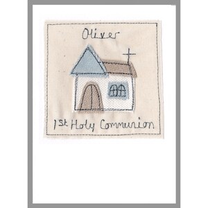 May include: A white card with a stitched design of a church with a cross on top. The card says "Oliver 1st Holy Communion" in black stitching.