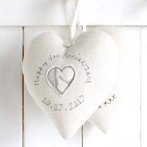May include: Two white heart-shaped fabric cushions with the text "Happy 4th Anniversary 30.07.2017 xxx" embroidered on them.