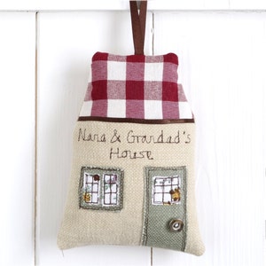 Personalised fabric hanging house decoration with a red gingham roof, embroidered with the words nana and grandads house