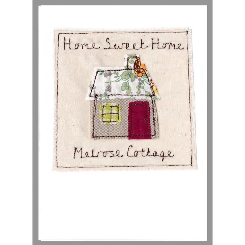 以下が含まれることがあります： 「Home Sweet Home Melrose Cottage」という文字と、赤いドアのある家が刺繍された白いカードです。
