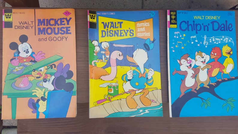 May include: Three vintage comic books featuring Walt Disney characters. The first comic book features Mickey Mouse and Goofy, the second features Donald Duck, and the third features Chip and Dale.