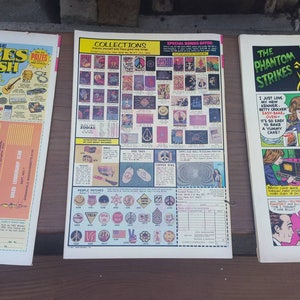 May include: Three comic books with colorful covers. The first comic book has a blue cover with the text "Choose Prizes of Cash at SLC". The second comic book has a red, white, and blue cover with the text "Collections". The third comic book has a red, white, and blue cover with the text "The Phantom Strikes".