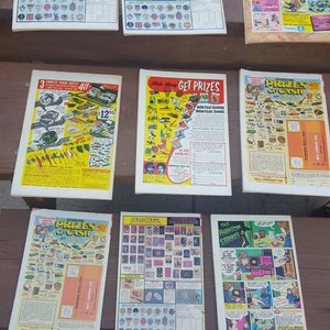 May include: A collection of vintage comic books featuring a variety of themes, including Wild Action, Get Prizes, Choose Prizes or Cash, and The Phantom Strikes. The comics feature colorful covers with illustrations of action-packed scenes and characters.