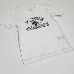 May include: White t-shirt with a black and blue graphic that says "FUTURE ROADRUNNER" in a collegiate font.