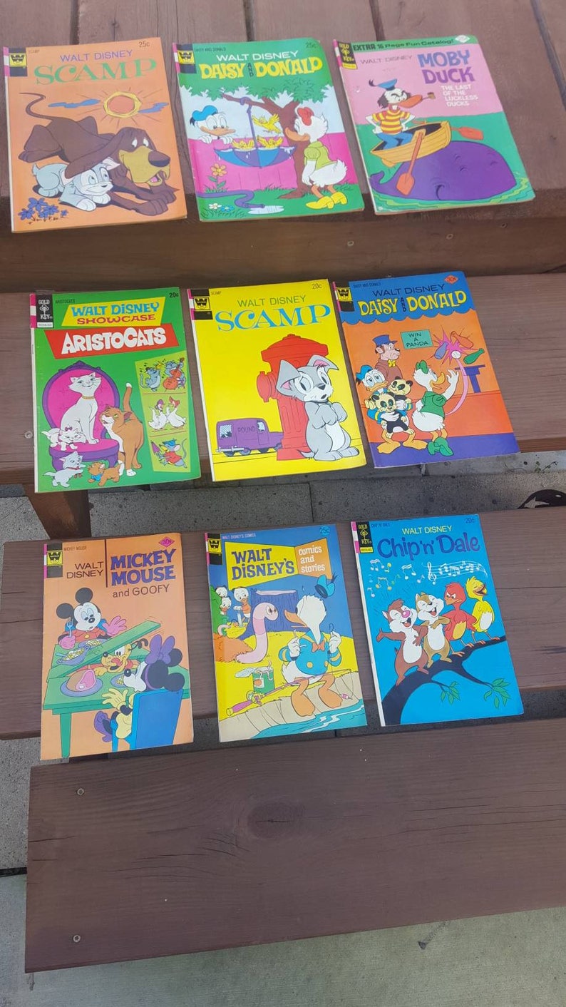 May include: A collection of nine vintage Walt Disney comic books featuring characters like Scamp, Daisy Duck, Donald Duck, Aristocats, Mickey Mouse, Goofy, and Chip 'n Dale. The comic books are in good condition and have colorful covers.