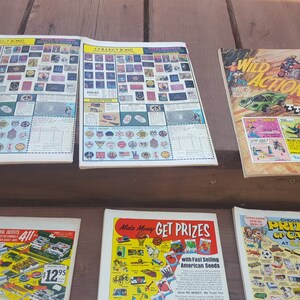 May include: A collection of vintage comic books featuring various themes, including Wild Action, Get Prizes, and a fishing guide. The covers feature colorful illustrations and text, including "Wild Action Deluxe Thrill Set" and "Make Money Get Prizes with Fast Selling American Seeds".