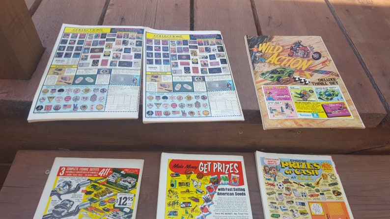 May include: A collection of vintage comic books featuring various themes, including Wild Action, Get Prizes, and a fishing guide. The covers feature colorful illustrations and text, including "Wild Action Deluxe Thrill Set" and "Make Money Get Prizes with Fast Selling American Seeds".