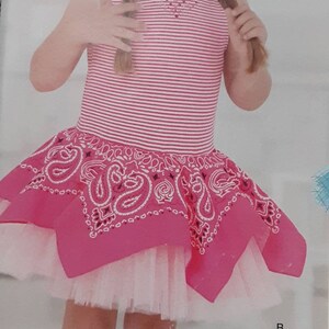 May include: A young girl wearing a pink and white striped sleeveless dress with a pink bandana print overlay and a white tulle underskirt. She is wearing pink cowboy boots.