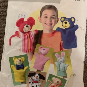 May include: A sewing pattern for making seven different hand puppets. The puppets include a cat, a dog, a monkey, a pig, a rabbit, a mouse, and a bear. The pattern is from Butterick and is labeled "Soft Stuff".