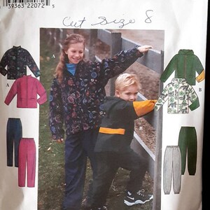 May include: Simplicity sewing pattern number 8342 for sizes 8, 10, 12, and 14. The pattern includes instructions for making a jacket and pants. The image shows two children modeling the finished garments. The girl is wearing a floral print jacket and blue pants. The boy is wearing a black jacket with orange accents and black pants. The pattern is for a cut size of 8.