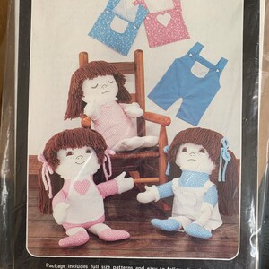 May include: A sewing pattern for making reversible 20-inch rag dolls. The pattern includes instructions for making doll clothes and different facial expressions. The pattern is called "Change of Heart Dolls" and is from Calico & Straw.