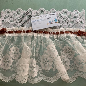 Puede incluir: Borde de encaje blanco con una cinta marr&oacute;n y dos pinzas para el pelo negras. El borde mide 29,2 cm de ancho y 22,9 cm de largo. El texto en la tarjeta dice "Crafty By Nature Blue".