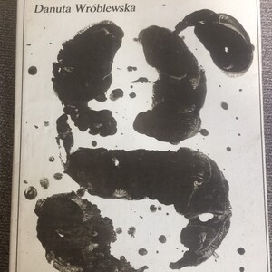 May include: A book cover with a black and white abstract design. The title of the book is "Polska grafika współczesna" and the author is "Danuta Wróblewska".