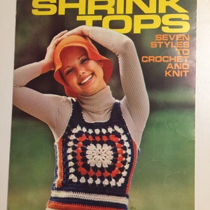 May include: A vintage magazine cover featuring a woman wearing an orange hat and a crocheted top. The top is navy blue, white, and orange. The magazine title is "SHRINK TOPS" with the subtitle "SEVEN STYLES TO CROCHET AND KNIT".