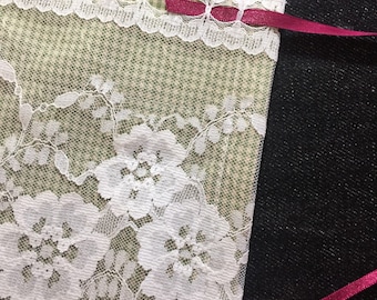 May include: A green and white gingham fabric with white lace trim and a pink ribbon tied around it.