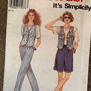 May include: A sewing pattern for a vest and shorts or pants. The pattern is for sizes 8-18 and is from Simplicity. The pattern shows two women wearing the vest and shorts or pants. The vest is a floral print and the shorts or pants are a solid color.