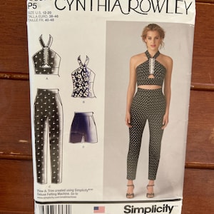 May include: A Simplicity sewing pattern featuring a Cynthia Rowley design. The pattern includes instructions for a halter top, pants, and shorts. The size range is U.S. 12-20. The image shows a woman wearing the completed outfit, a black and white polka dot halter top and pants.