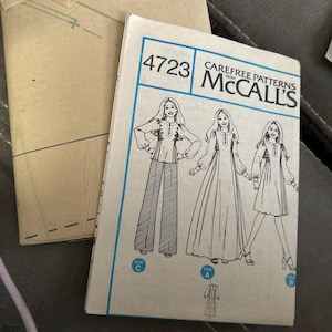 May include: A vintage McCall's 4723 Carefree Patterns sewing pattern envelope featuring illustrations of three garment styles labeled View A, B, and C. The front cover displays a long dress, a short dress, and a blouse with pants, all with long sleeves.