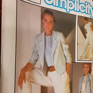 Op de afbeelding: Een Simplicity naaipatroon voor een damespak. Het patroon bevat een blazer en een broek. Het model draagt een witte blazer met dunne strepen, een lichtblauw blouse en een witte broek. Het patroonnummer is 674.