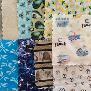 May include: A set of eight reusable food wraps with various patterns. The patterns include bees and avocados, lemons, peace signs, stars, and a beehive. The wraps are made of fabric and are designed to be used as a sustainable alternative to plastic wrap.