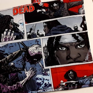 May include: A fabric panel with a comic book style design featuring characters from The Walking Dead. The panel features a red, white, and blue color scheme with images of characters from the show, including Rick Grimes, Michonne, and Daryl Dixon. The text "The Walking Dead" is printed in white on a black background.