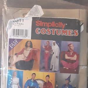 Pode incluir: Padrão de costura Simplicity Costumes #39363, com oito ideias de fantasias diferentes. O padrão inclui uma variedade de estilos, incluindo uma túnica branca, uma fantasia vermelha e dourada, uma fantasia azul e branca e uma fantasia vermelha e dourada. O padrão é rotulado como "Fácil" e é para os tamanhos S, M e L.