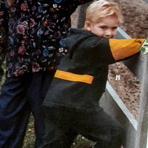 May include: Two children, one wearing a black and floral patterned jacket and the other wearing a black and yellow sweatshirt, are standing next to a wooden fence. The text "Cut Size 8" is written on the top of the image.