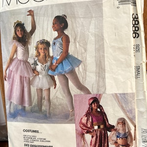 May include: McCall's sewing pattern for children's costumes. The image shows girls in various costumes, including a princess, ballerina, and harem girl. The pattern includes instructions for making these costumes.