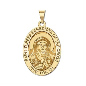 Puede incluir: Pendiente ovalado dorado con una imagen en relieve de Santa Teresa Benedicta de la Cruz. El pendiente tiene las palabras "Santa Teresa Benedicta de la Cruz Ruega por Nosotros" inscritas alrededor del borde.