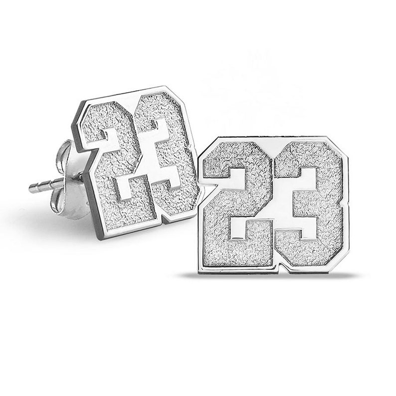 May include: A pair of silver earrings, each featuring the number 23 in a square shape with a textured surface.