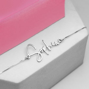 Peut inclure: Un collier en argent avec le nom "Sophia" &eacute;crit en cursive.