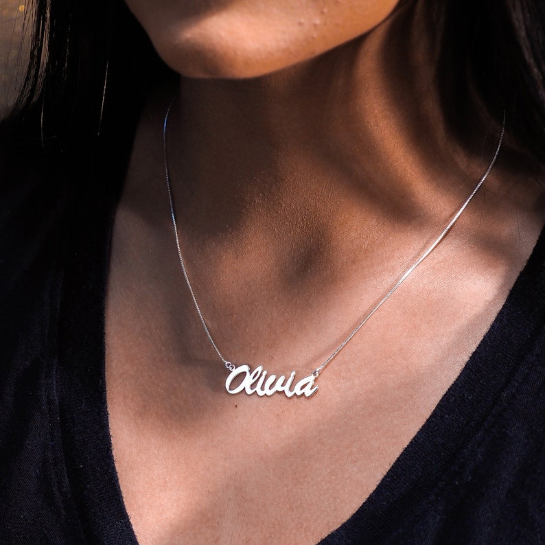 Olivia name necklace in silver on a woman