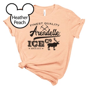 May include: A peach colored t-shirt with a black graphic design that says "Finest Quality Arendelle Ice Co. Since 2013". The graphic also includes a pair of crossed pickaxes and a reindeer.
