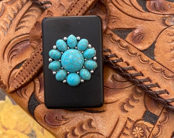May include: A black lighter with a turquoise and silver turquoise stone design.