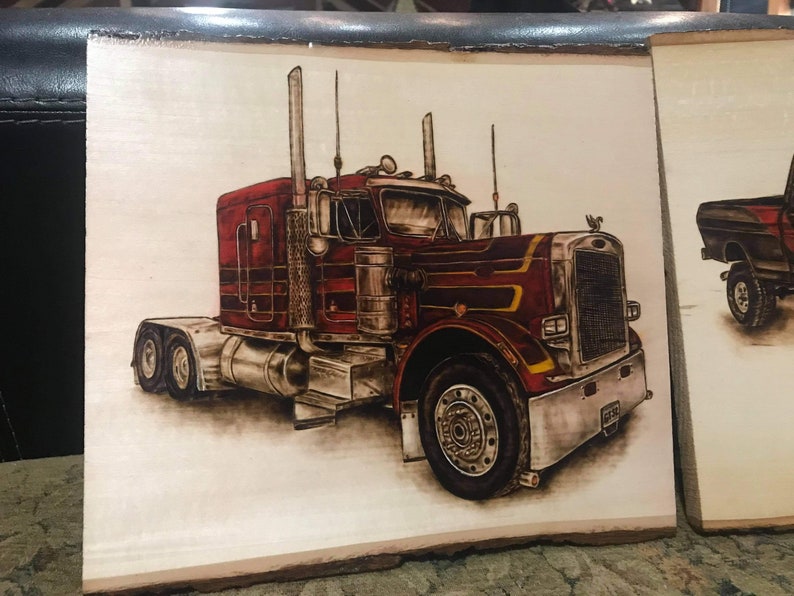 Op de afbeelding: Een in hout gebrand beeld van een rode vrachtwagen met chroomaccenten. De vrachtwagen staat op een houten achtergrond.