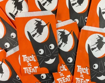 Pode incluir: Um monte de sacos de guloseimas de Halloween laranja e branco com um design de gato preto e bruxa. Os sacos têm o texto "Trick or Treat" impresso neles.