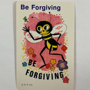 Op de afbeelding: Een vintage kaart met de woorden "Be Forgiving" bovenaan en onderaan. In het midden staat een cartoonbij met een geel en zwart gestreept lichaam en grote ogen. Er zijn ook kleurrijke bloemen en een vlinder aanwezig.