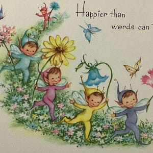 May include: A greeting card illustration featuring five small fairies in colorful outfits—blue, purple, yellow, and dark blue—dancing through a field of flowers. Butterflies flutter nearby, and the text reads, Happier than words can tell....
