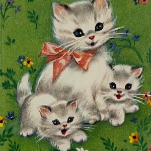K&ouml;nnte beinhalten: Eine Illustration im Vintage-Stil mit drei flauschigen wei&szlig;en und grauen K&auml;tzchen auf gr&uuml;nem Hintergrund mit kleinen bunten Blumen. Das gr&ouml;&szlig;te K&auml;tzchen sitzt in der Mitte und tr&auml;gt eine orange-rote Schleife, flankiert von zwei kleineren.