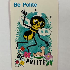 Op de afbeelding: Een vintage kaart met een cartoon illustratie van een bij en een worm. De bij is zwart en geel met grote ogen, en de worm is lichtbruin. De kaart toont de woorden "Be Polite" in blauw en "BE POLITE" in roze en geel.