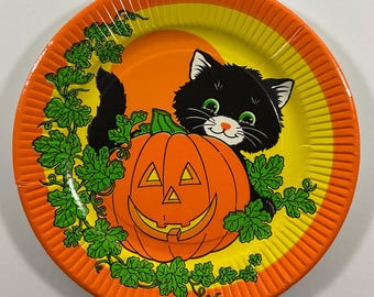 May include: Orange and yellow paper plate with a black cat peeking out from behind a jack-o'-lantern pumpkin. The plate has a green vine design around the edge.