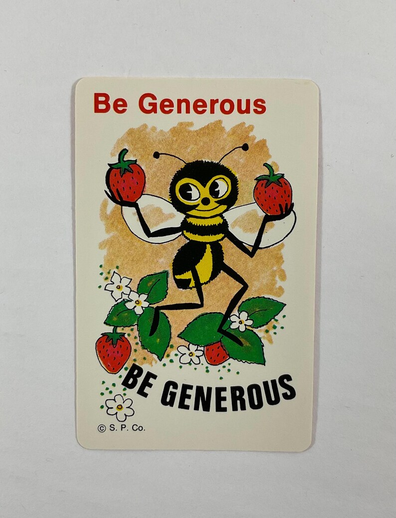 Op de afbeelding: Een vintage kaart met een cartoon bij die twee rode aardbeien vasthoudt. De bij is zwart en geel met een lachend gezicht. De kaart heeft de tekst "Be Generous" in rode tekst bovenaan en onderaan.