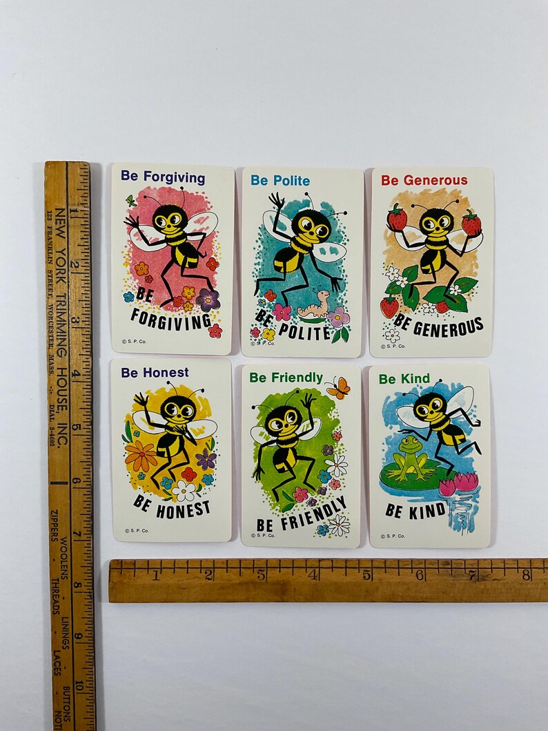 Op de afbeelding: Set van zes vintage kaarten met cartoonbijen en berichten als "Wees vergevingsgezind" en "Wees aardig". Elke kaart heeft een andere kleurrijke achtergrond en illustraties van bloemen, fruit en een kikker. De kaarten zijn rechthoekig met afgeronde hoeken.